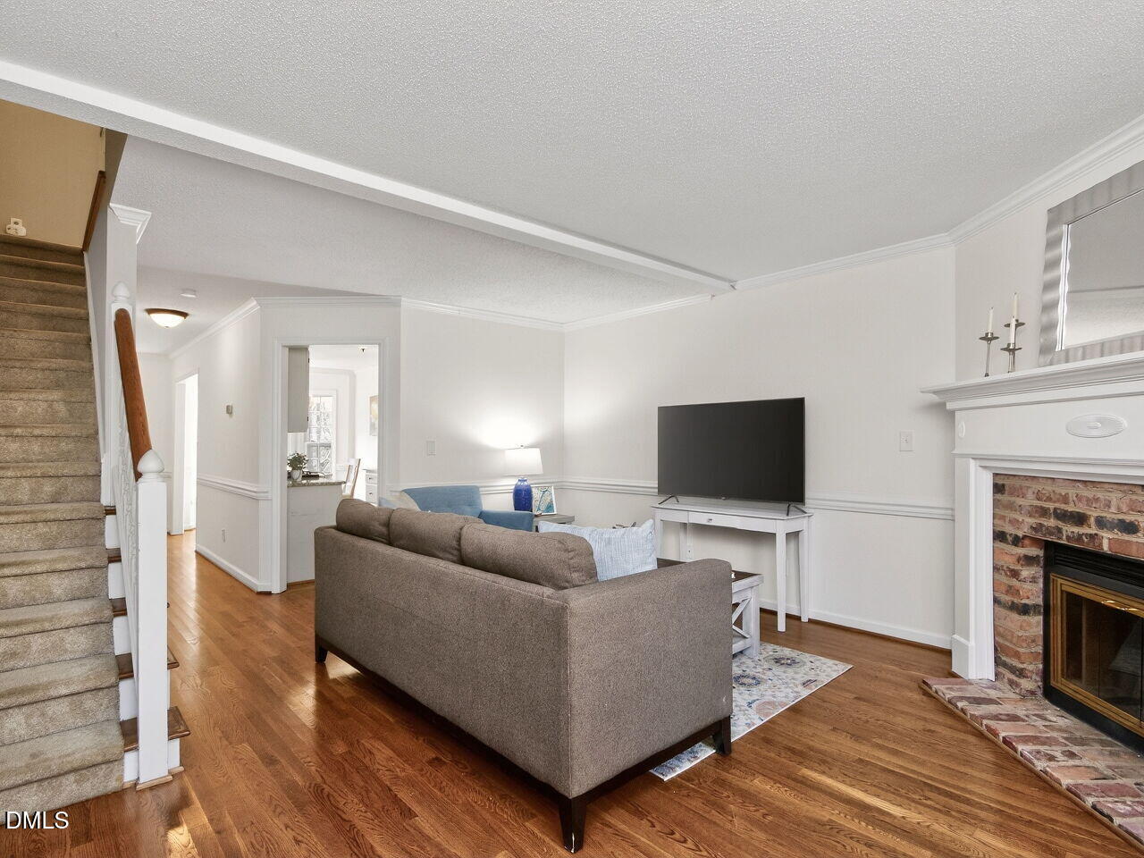 6703 Queen Annes Drive Raleigh, NC 27613 - Photo 9 of 20 a living room with furniture a fireplace and a flat screen tv
