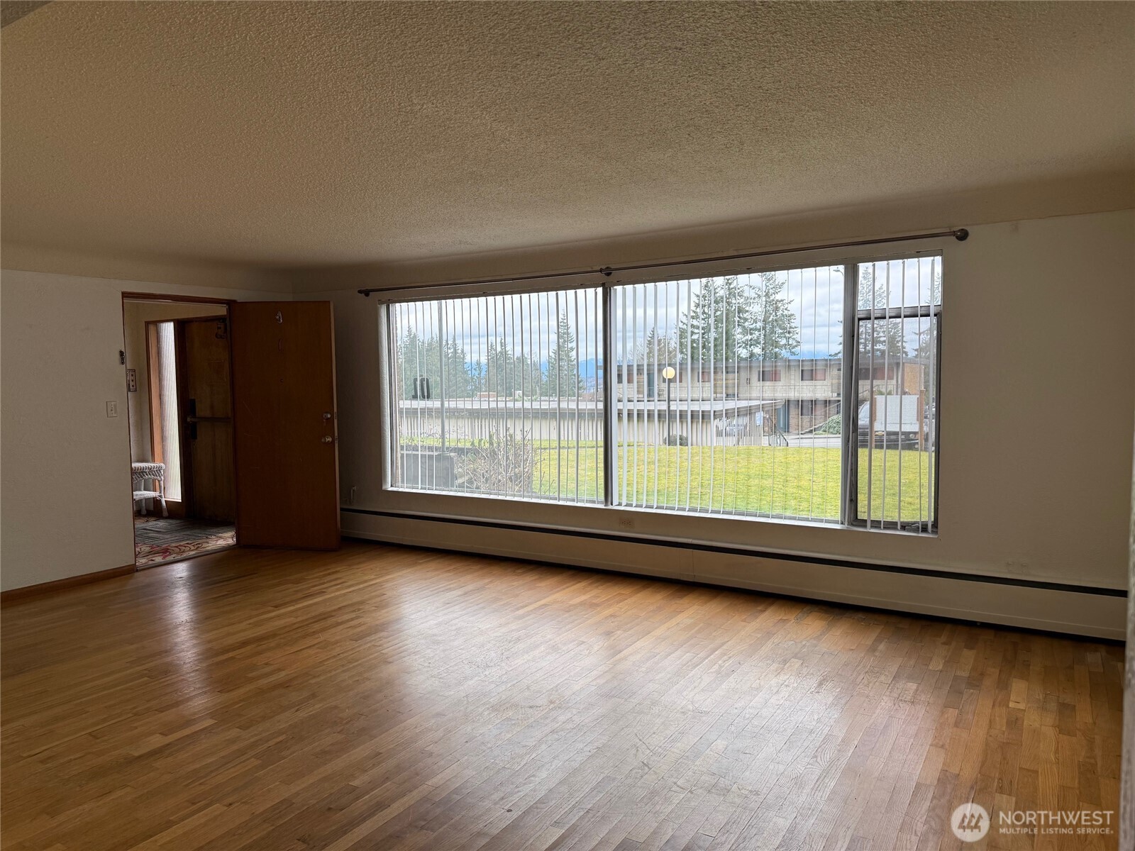 5120 Colby Avenue, Unit 1 Everett, WA 98203 - Photo 2 of 9 an empty room with wooden floor and windows
