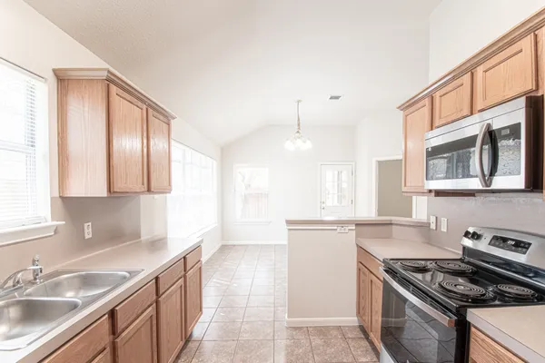 a kitchen with stainless steel appliances granite countertop a sink stove and cabinets