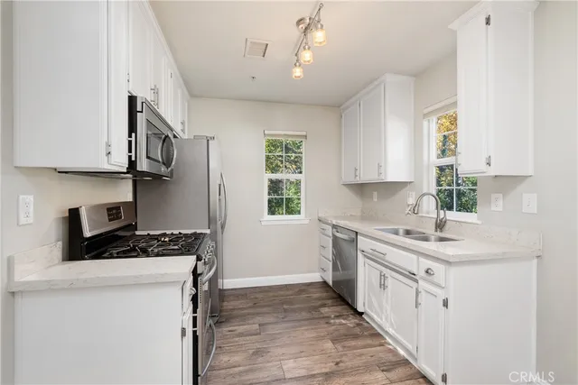 a kitchen with stainless steel appliances a sink stove and cabinets