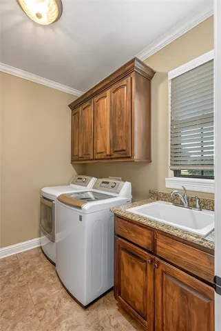 a utility room with a sink washer and dryer