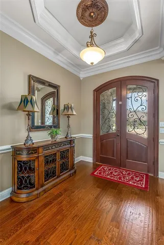 a living room with stainless steel appliances granite countertop a stove and a wooden floor
