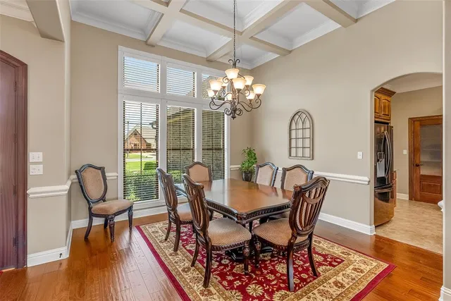 a dining room with furniture a chandelier and wooden floor
