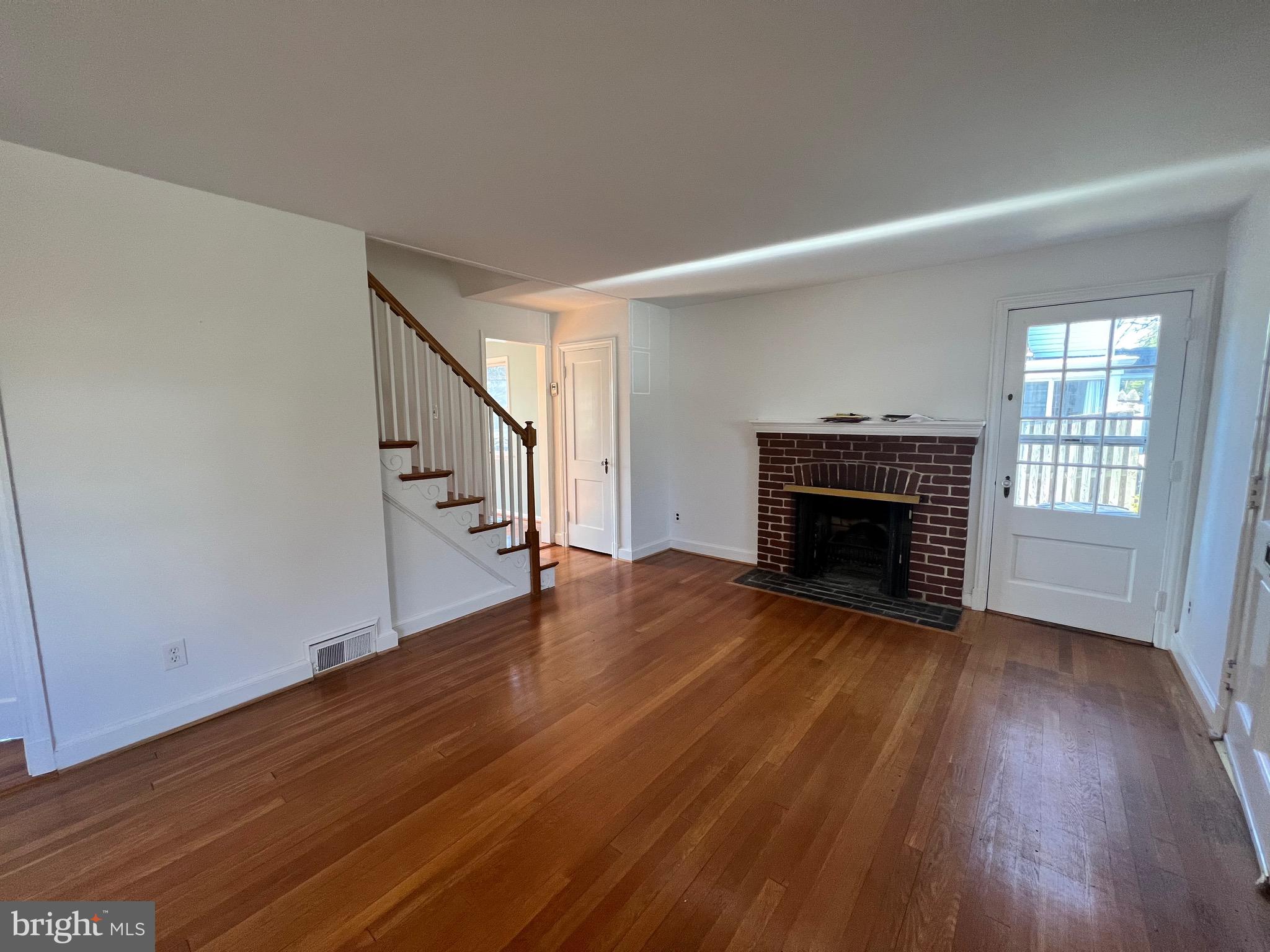318 Whitestone Road Silver Spring, MD 20901 - Photo 11 of 23 a view of empty room with wooden floor and fireplace