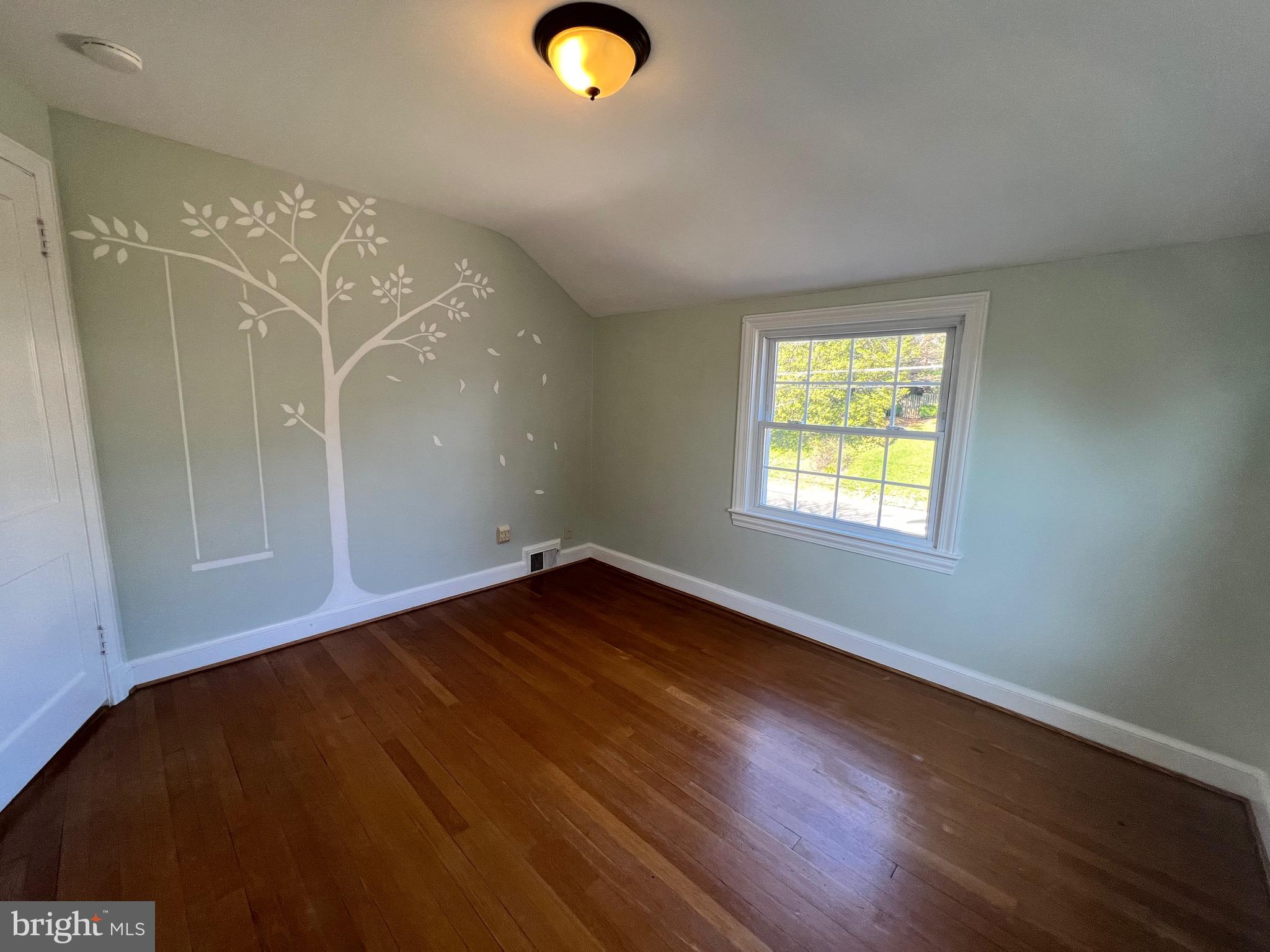 318 Whitestone Road Silver Spring, MD 20901 - Photo 20 of 23 an empty room with wooden floor and windows