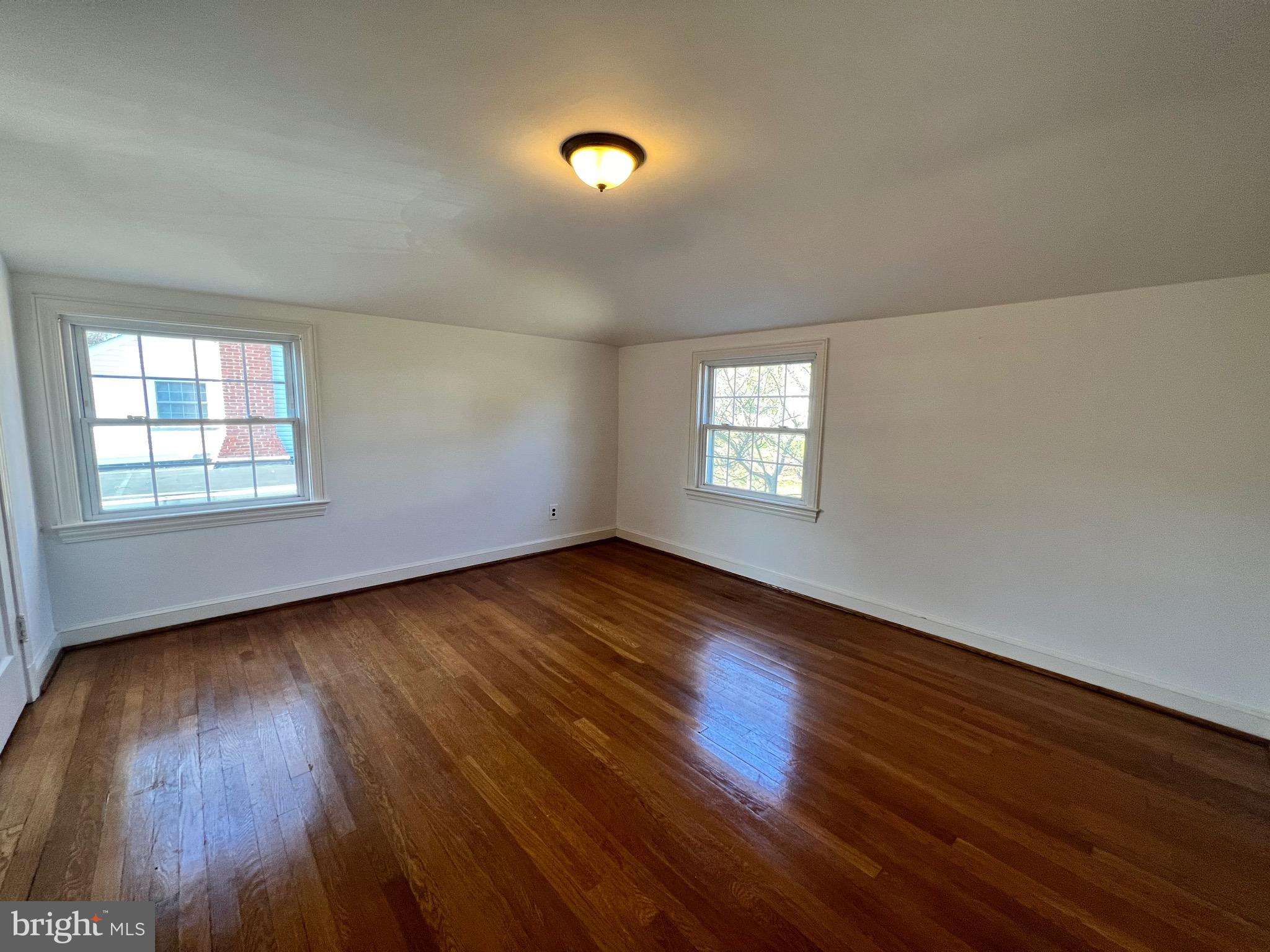 318 Whitestone Road Silver Spring, MD 20901 - Photo 22 of 23 a view of an empty room with wooden floor and a window