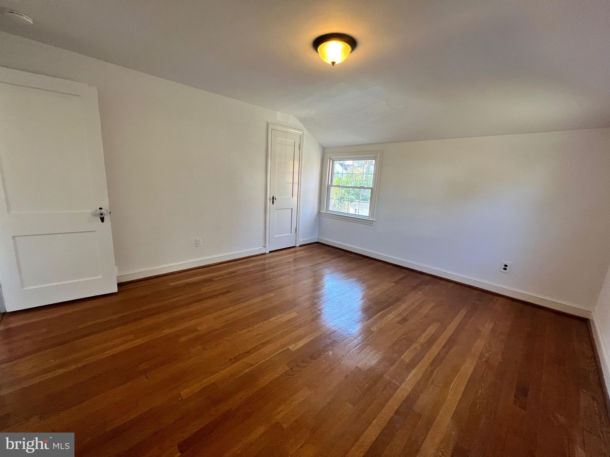 318 Whitestone Road Silver Spring, MD 20901 - Photo 4 of 23 a view of an empty room with wooden floor and a window