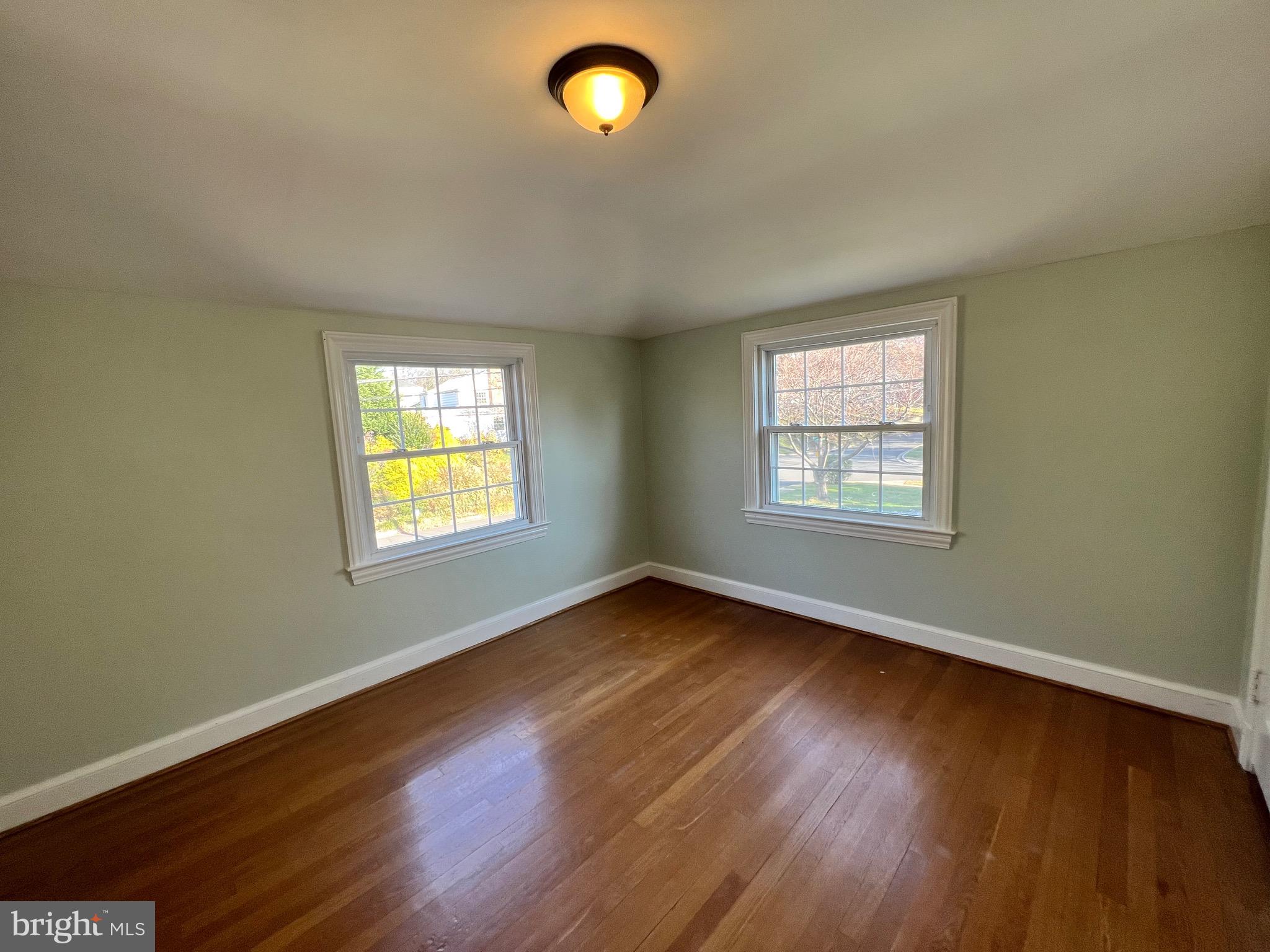 318 Whitestone Road Silver Spring, MD 20901 - Photo 6 of 23 an empty room with wooden floor and windows