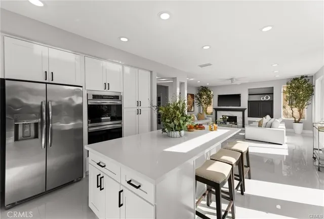 a kitchen with granite countertop a refrigerator and a stove top oven