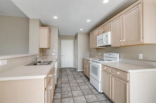 a kitchen with a sink stove top oven and cabinets