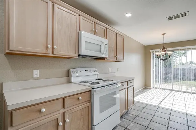 a kitchen with stainless steel appliances granite countertop a stove a sink and a white cabinets