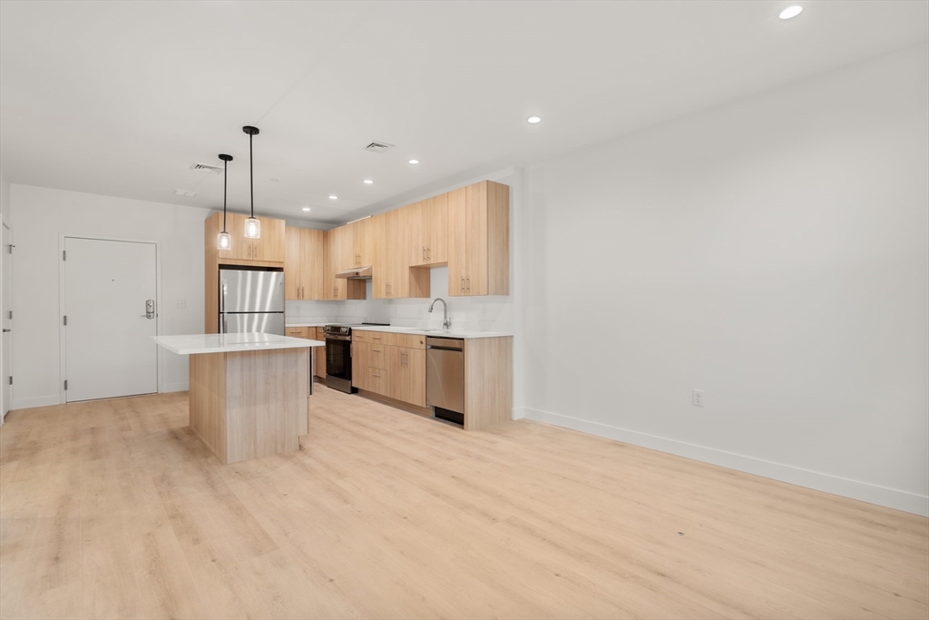 1151 Walnut Street, Unit 406 Newton, MA 02461 - Photo 15 of 32 a kitchen with stainless steel appliances granite countertop a sink a stove a refrigerator and white cabinets