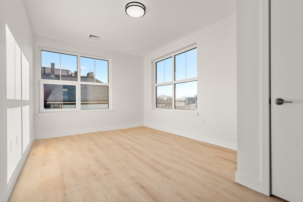1151 Walnut Street, Unit 406 Newton, MA 02461 - Photo 18 of 32 a view of an empty room with window and wooden floor