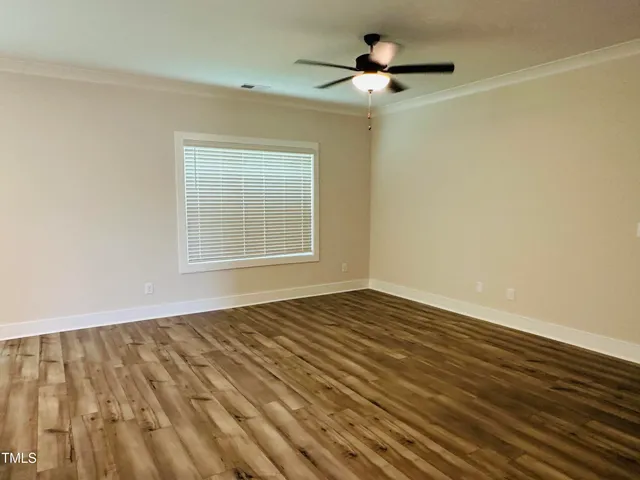 a view of an empty room with a window and a ceiling fan