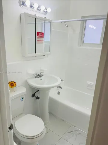 a bathroom with a sink mirror vanity and toilet