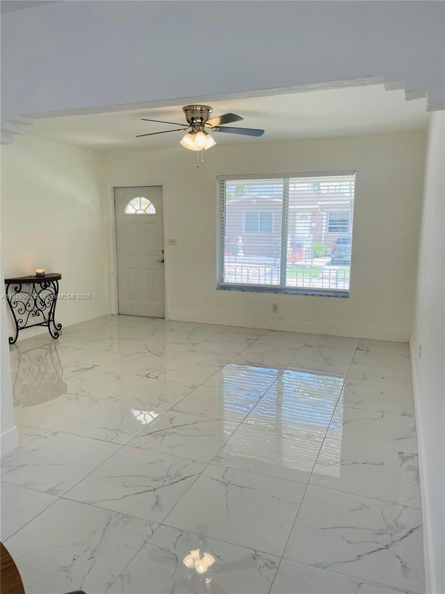 3175 Southwest 27th Terrace, Unit 3175 Miami, FL 33133 - Photo 7 of 17 a view of a livingroom with furniture and chandelier fan