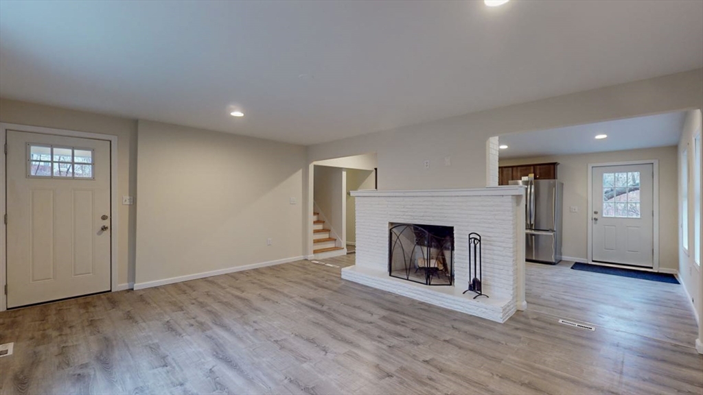 195 Riverton Road Springfield, MA 01109 - Photo 12 of 42 an empty room with wooden floor fireplace and cabinet