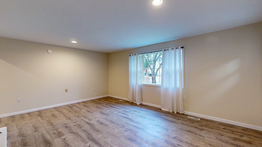 195 Riverton Road Springfield, MA 01109 - Photo 14 of 42 an empty room with wooden floor and windows