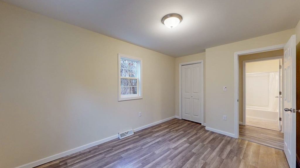 195 Riverton Road Springfield, MA 01109 - Photo 18 of 42 an empty room with wooden floor and windows