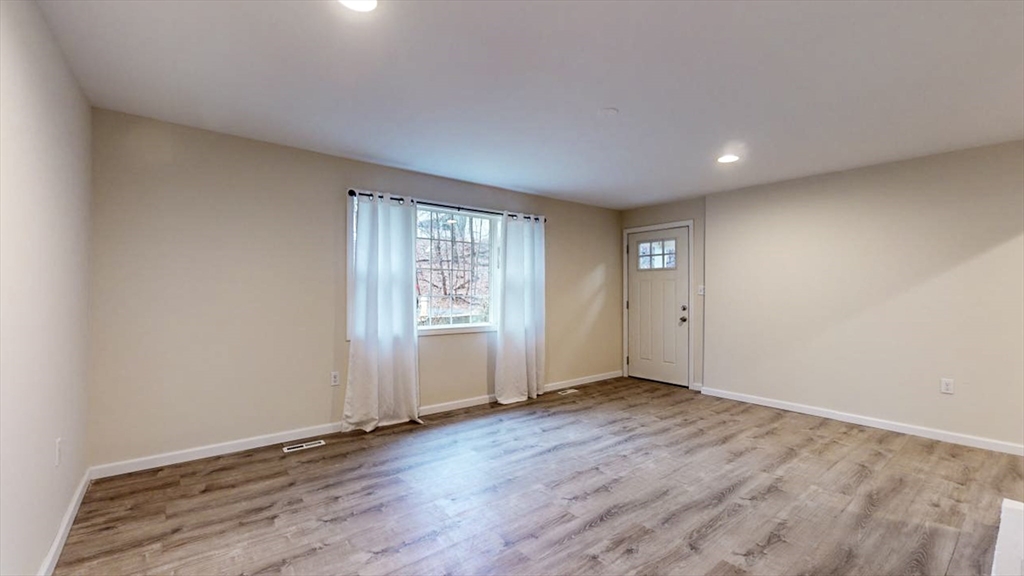 195 Riverton Road Springfield, MA 01109 - Photo 29 of 42 an empty room with wooden floor and windows