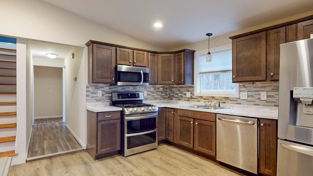 195 Riverton Road Springfield, MA 01109 - Photo 6 of 42 a kitchen with stainless steel appliances granite countertop a stove top oven a sink and a microwave
