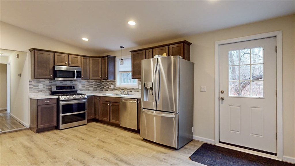 195 Riverton Road Springfield, MA 01109 - Photo 10 of 42 a kitchen with granite countertop stainless steel appliances a refrigerator cabinets and wooden floor