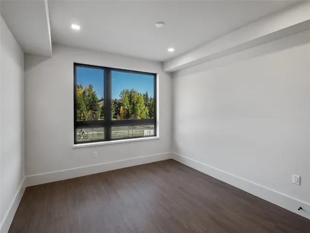 an empty room with wooden floor and closet