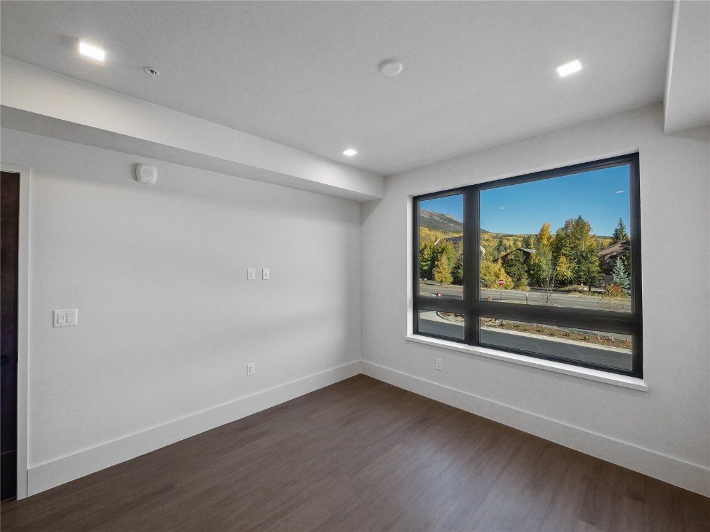 80 West Main Street, Unit 212 Frisco, CO 80443 - Photo 30 of 45 an empty room with wooden floor and windows