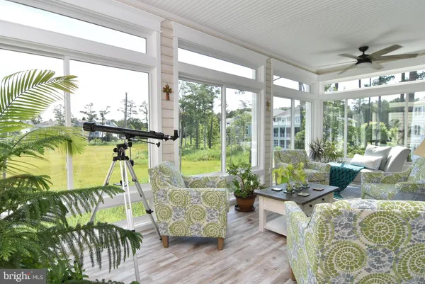 a view of a patio with table and chairs and potted plants with wooden floor and fence