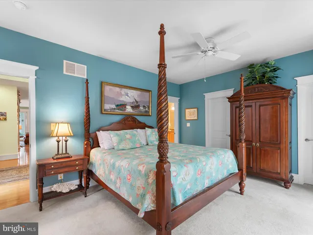 a bedroom with a large bed and a chandelier