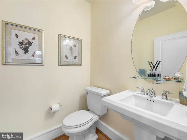 a bathroom with a granite countertop sink a toilet and a large mirror
