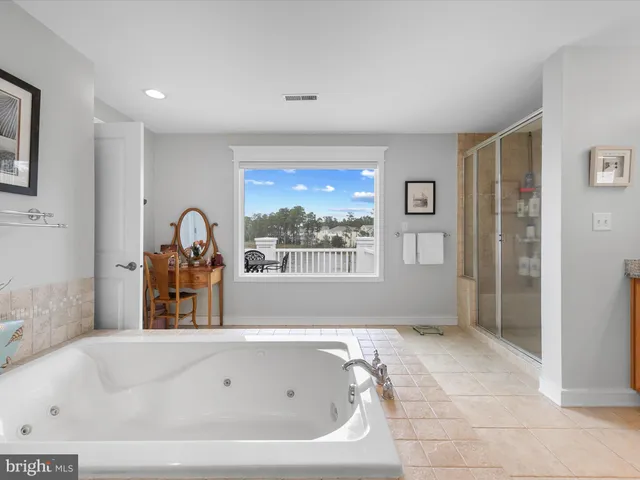 a bedroom with a large bed and a chandelier fan