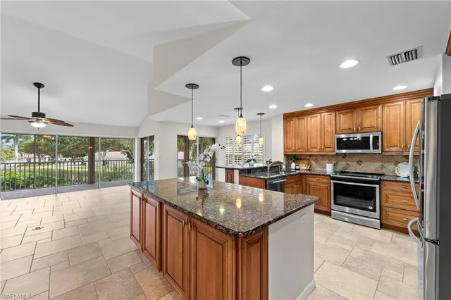a kitchen with stainless steel appliances granite countertop a sink a stove and a refrigerator