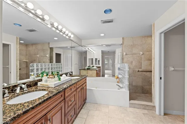 a large bathroom with a double vanity sink a mirror and a bathtub