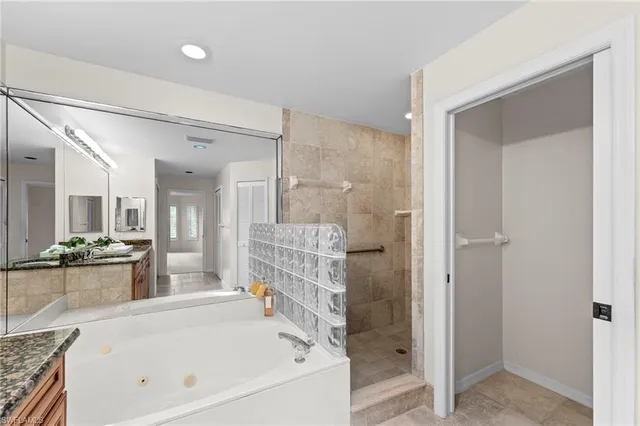 a bathroom with a tub a sink and a large mirror