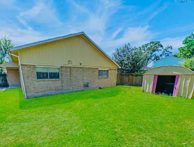 a view of a backyard with potted plants and large tree