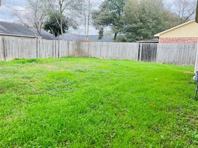 a view of backyard with wooden fence