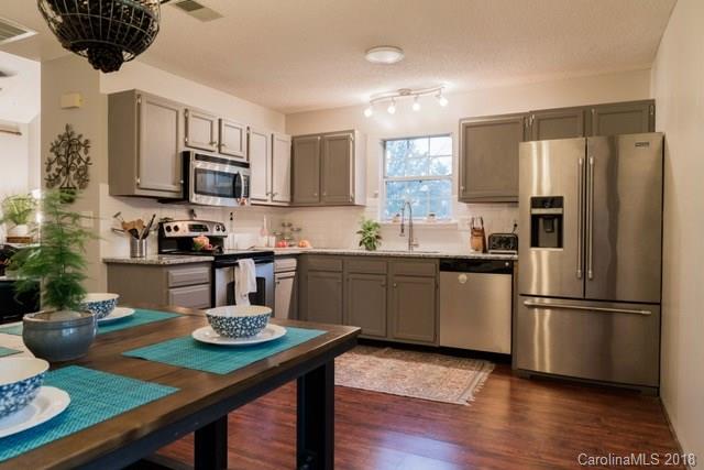 8209 Golf Ridge Drive Charlotte, NC 28277 - Photo 8 of 21 a kitchen with stainless steel appliances granite countertop a sink dishwasher a refrigerator a stove a microwave oven with cabinets and wooden floor