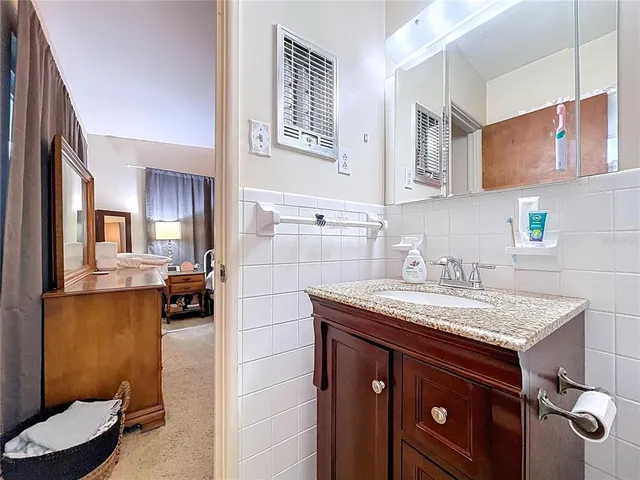 a bathroom with a granite countertop sink a mirror and shower
