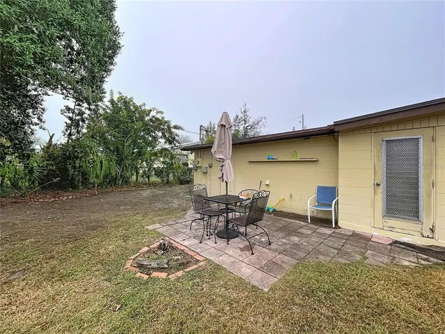 a view of a patio with table and chairs with wooden fence