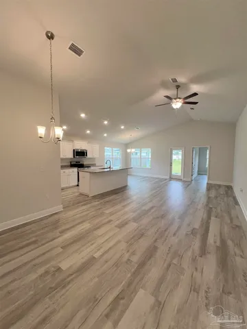 a view of a room with a ceiling fan wooden floor and a ceiling fan
