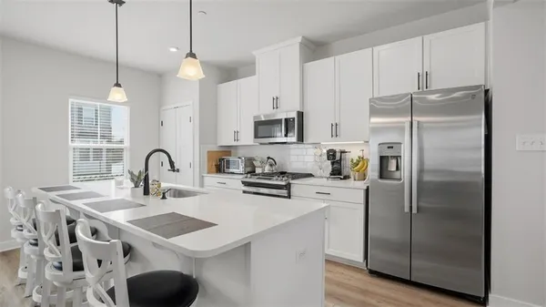 a kitchen with kitchen island a sink appliances and cabinets