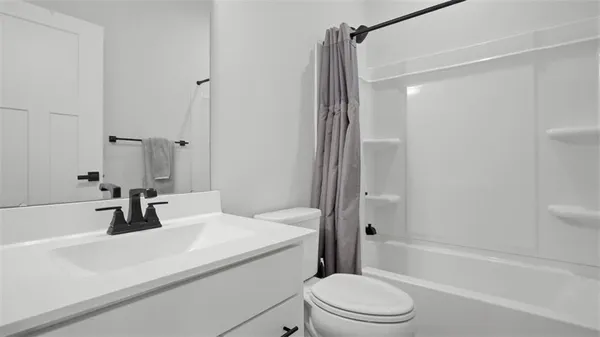 a bathroom with a sink a toilet a mirror and shower