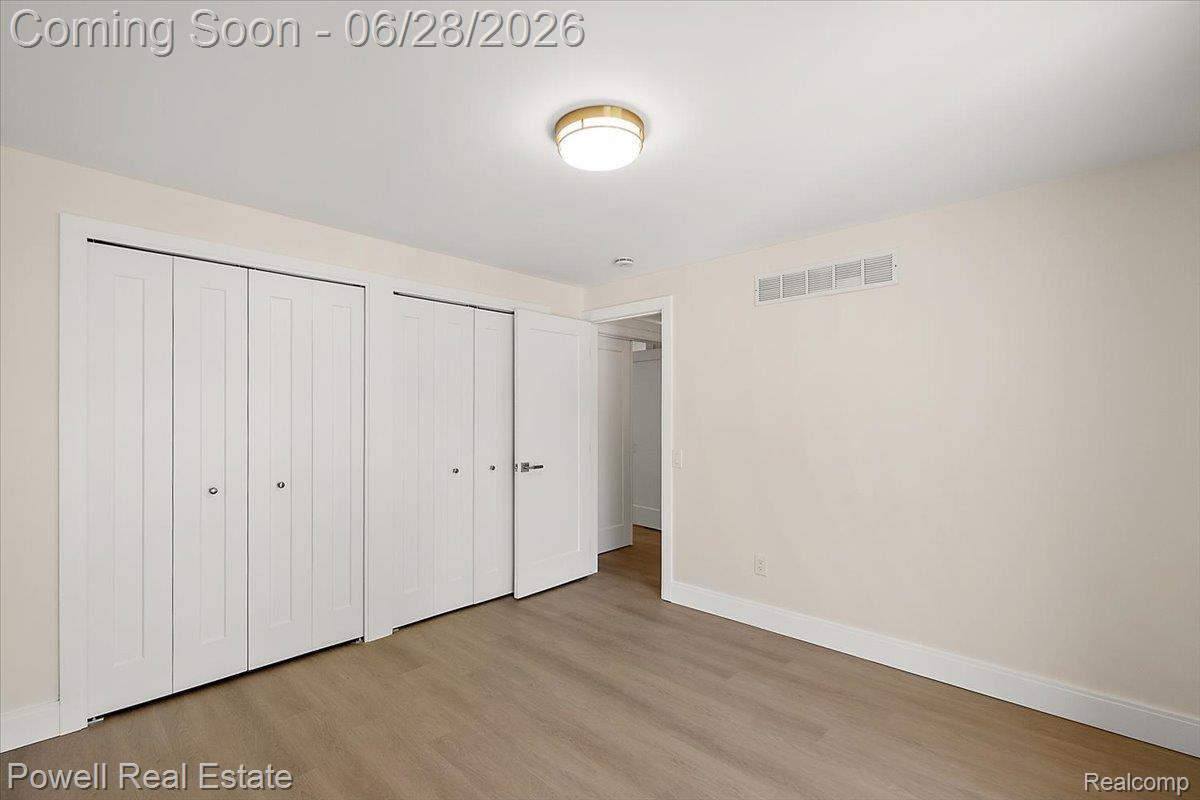 1447 Ravineview Court, Unit C12 Bloomfield Hills, MI 48304 - Photo 39 of 49 Neutral-toned interior featuring wood-finish flooring, white baseboards, and a contemporary ceiling light fixture