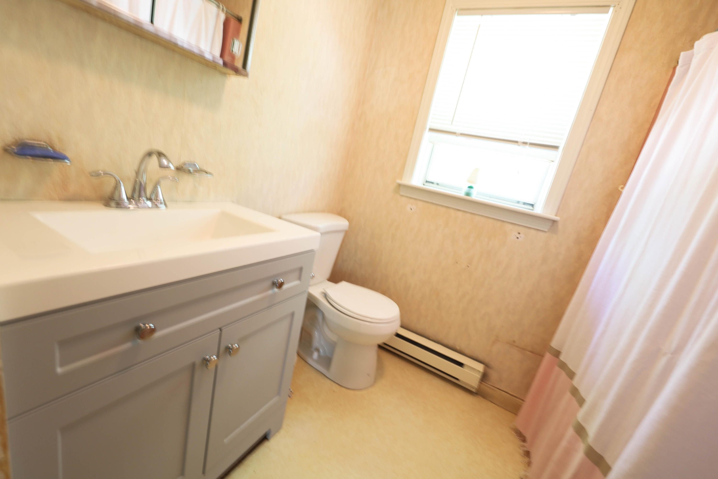 91 Quashnet Road Mashpee, MA 02649 - Photo 13 of 16 a bathroom with a sink a toilet and a mirror