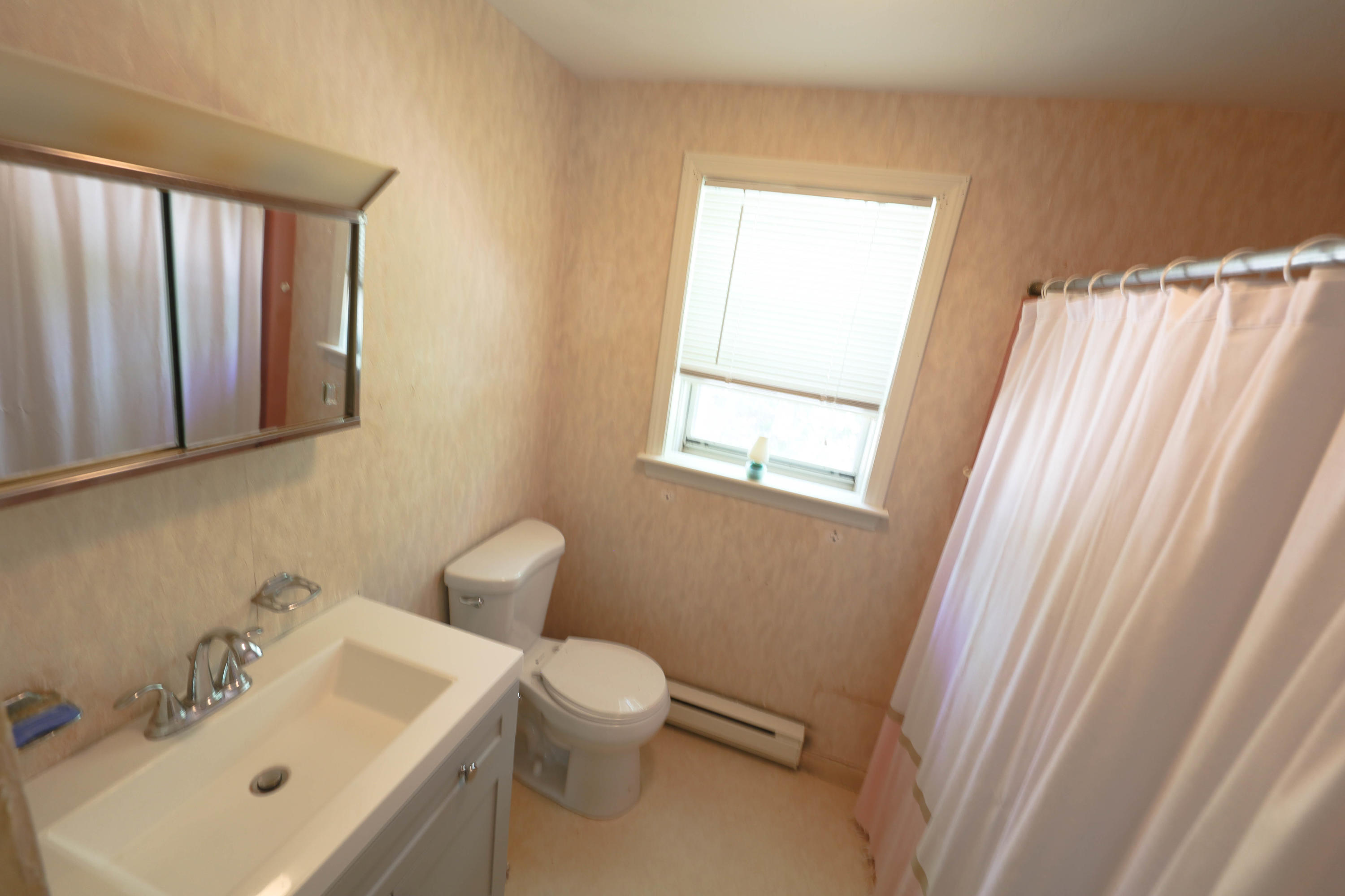 91 Quashnet Road Mashpee, MA 02649 - Photo 14 of 16 a white toilet sitting next to a bathroom sink