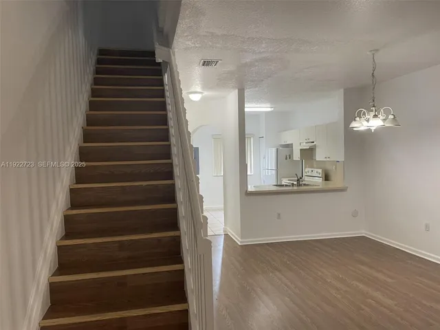 a view of an entryway with wooden floor and staircase
