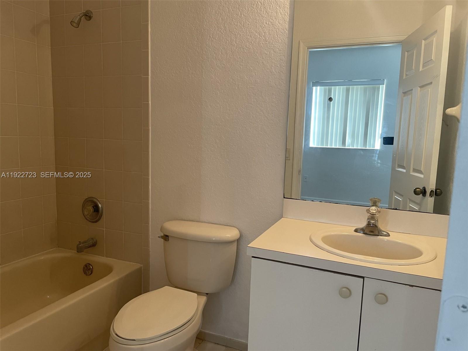 8831 South Isles Circle, Unit 8831 Tamarac, FL 33321 - Photo 15 of 22 a bathroom with a sink a toilet and shower