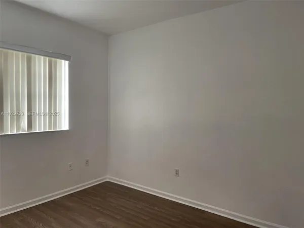 a view of a small space with wooden floor and a window