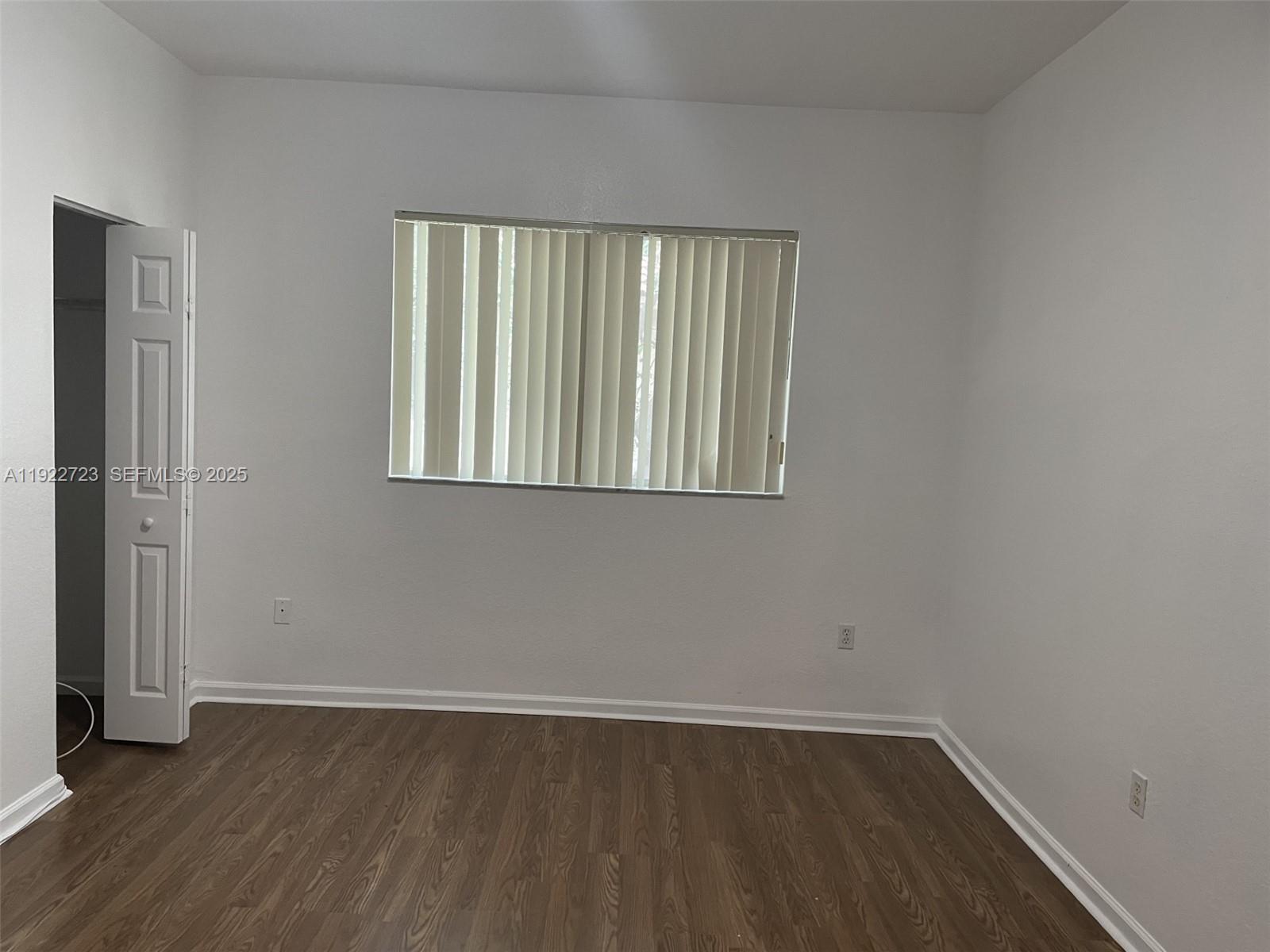 8831 South Isles Circle, Unit 8831 Tamarac, FL 33321 - Photo 17 of 22 an empty room with wooden floor and windows
